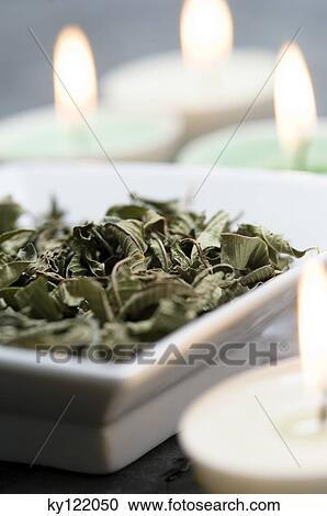 Stock Image - Dried mint leaves and candles, close-up. Fotosearch