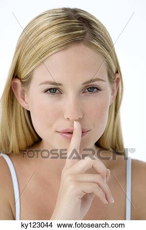 Picture - Portrait of a young woman, finger on her mouth. Fotosearch