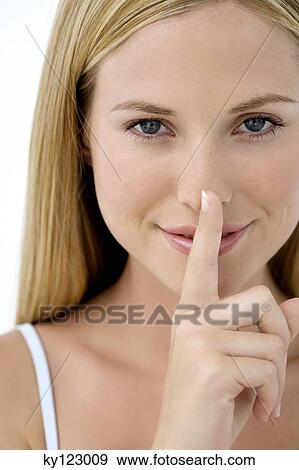 Portrait of a young woman, finger on her mouth View Large Photo Image Stock Photo - Portrait of a young woman, finger on her mouth. Fotosearch