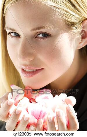 Portrait of a young woman holding petals flowers, indoors (studio) View Large Photo Image Stock Photography - Portrait of a young woman holding petals flowers, indoors (studio). Fotosearch