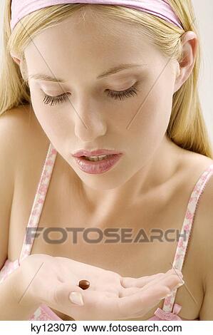 Portrait of a young woman looking at a brown tablet in her hand, indoors (studio) View Large Photo Image Stock Photo - Portrait of a young woman looking at a brown tablet in her hand, indoors (studio). Fotosearch