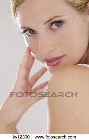 Portrait of a young woman looking at the camera, hand on her cheek, indoors (studio) View Large Photo Image Stock Image - Portrait of a young woman looking at the camera, hand on her cheek, indoors (studio). Fotosearch
