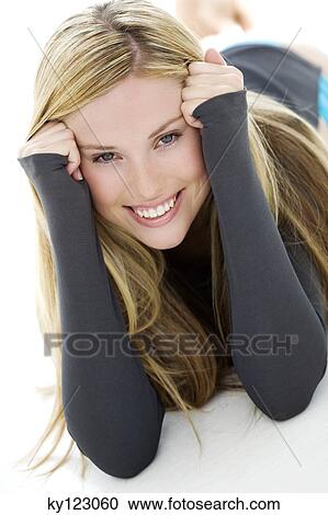 Stock Image - Portrait of a young woman looking at the camera, indoors (studio). Fotosearch