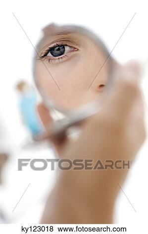 Portrait of a young woman looking at herself in a mirror, indoors (studio) View Large Photo Image Stock Photo - Portrait of a young woman looking at herself in a mirror, indoors (studio). Fotosearch