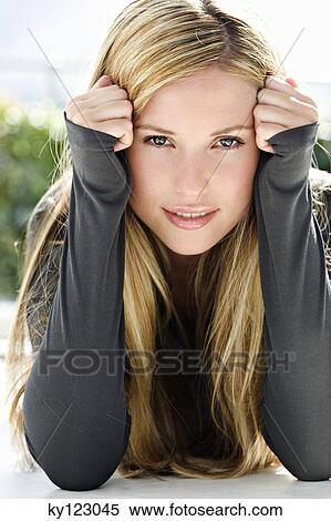 Portrait of a young woman looking at the camera, indoors (studio) View Large Photo Image Stock Photography - Portrait of a young woman looking at the camera, indoors (studio). Fotosearch