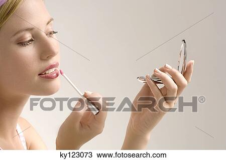 Portrait of a young woman making-up her mouth, indoors (studio) View Large Photo Image Stock Image - Portrait of a young woman making-up her mouth, indoors (studio). Fotosearch