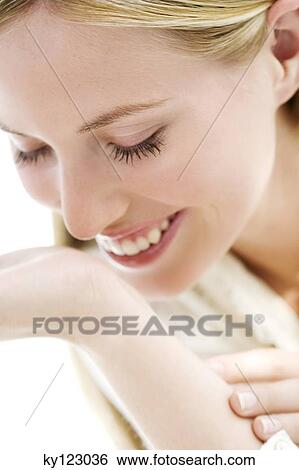 Portrait of a young woman smelling her wrist View Large Photo Image Stock Photograph - Portrait of a young woman smelling her wrist. Fotosearch