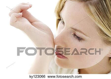 Portrait of a young woman smelling her wrist View Large Photo Image Stock Photograph - Portrait of a young woman smelling her wrist. Fotosearch