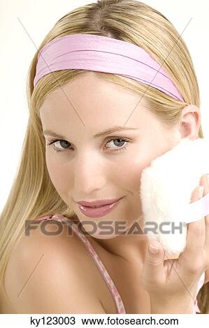Portrait of a young woman with powder puff on her cheek, indoors (studio) View Large Photo Image Stock Image - Portrait of a young woman with powder puff on her cheek, indoors (studio). Fotosearch