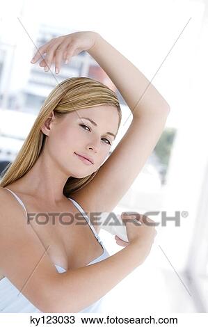 Young woman applying deodorant, indoors View Large Photo Image Stock Image - Young woman applying deodorant, indoors. Fotosearch