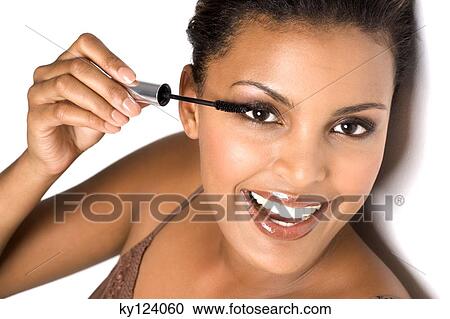 Portrait of a smiling woman applying mascara View Large Photo Image Stock Image - Portrait of a smiling woman applying mascara. Fotosearch