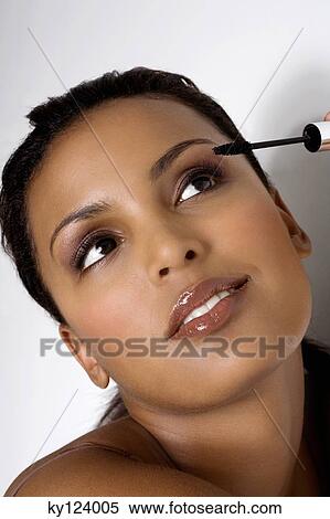 Portrait of a woman applying mascara View Large Photo Image Stock Photography - Portrait of a woman applying mascara. Fotosearch