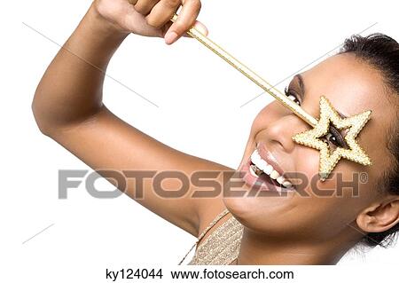Picture - Portrait of a young smiling woman looking through magic wand. Fotosearch