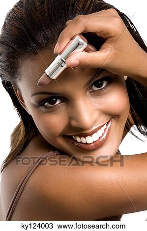 Portrait of a young smiling woman, holding lipstick View Large Photo Image Stock Image - Portrait of a young smiling woman, holding lipstick. Fotosearch