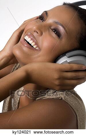 Portrait of a young smiling woman, listening to music with headphones View Large Photo Image Stock Image - Portrait of a young smiling woman, listening to music with headphones. Fotosearch
