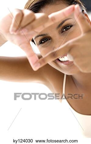 Portrait of a young smiling woman making a frame with her fingers View Large Photo Image Stock Image - Portrait of a young smiling woman making a frame with her fingers. Fotosearch