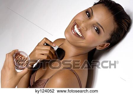 Portrait of a young smiling woman applying make-up View Large Photo Image Stock Image - Portrait of a young smiling woman applying make-up. Fotosearch