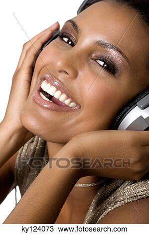 Portrait of a young smiling woman, listening to music with headphones View Large Photo Image Stock Image - Portrait of a young smiling woman, listening to music with headphones. Fotosearch