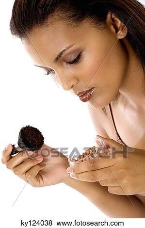 Portrait of a young smiling woman applying make-up View Large Photo Image Stock Photo - Portrait of a young smiling woman applying make-up. Fotosearch