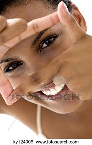 Portrait of a young smiling woman making a frame with her fingers View Large Photo Image Stock Photograph - Portrait of a young smiling woman making a frame with her fingers. Fotosearch