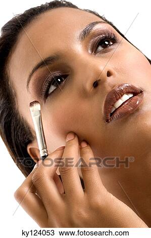 Portrait of a young woman applying eyeshadow View Large Photo Image Stock Image - Portrait of a young woman applying eyeshadow. Fotosearch