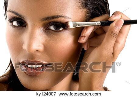 Portrait of a young woman applying eyeshadow View Large Photo Image Stock Photo - Portrait of a young woman applying eyeshadow. Fotosearch