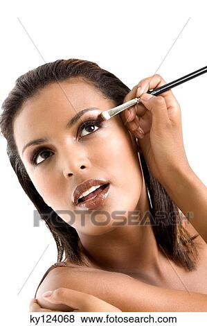 Portrait of a young woman applying eyeshadow View Large Photo Image Stock Photo - Portrait of a young woman applying eyeshadow. Fotosearch