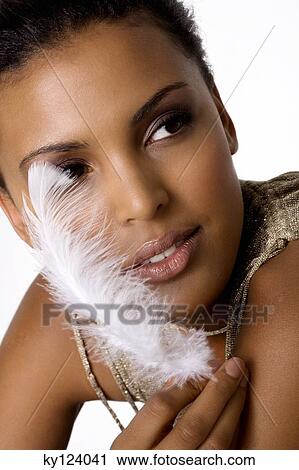 Portrait of a young woman holding feather View Large Photo Image Stock Image - Portrait of a young woman holding feather. Fotosearch