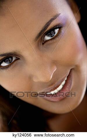 Portrait of a young woman looking at the camera View Large Photo Image Stock Photograph - Portrait of a young woman looking at the camera. Fotosearch