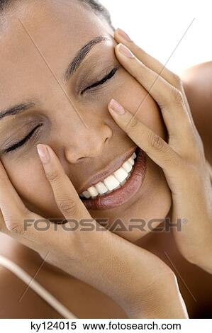 Stock Photography - Portrait of a young woman with hands on cheeks, eyes closed. Fotosearch
