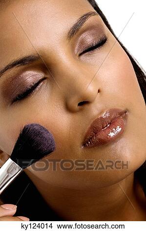 Picture - Young woman applying blush. Fotosearch