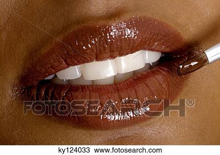 Young woman applying lipstick, close-up View Large Photo Image Stock Image - Young woman applying lipstick, close-up. Fotosearch