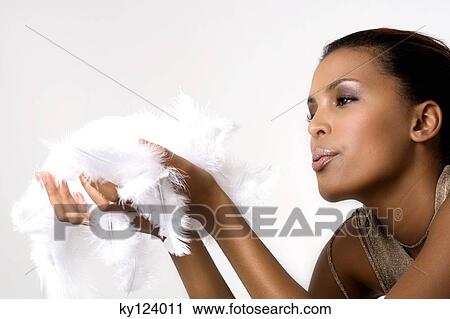 Young woman blowing over feathers View Large Photo Image Stock Image - Young woman blowing over feathers. Fotosearch