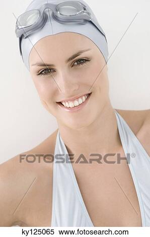 Stock Photography - Portrait of a young smiling woman with bikini, swimming cap and goggles. Fotosearch