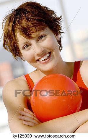 Portrait of a young woman with red ball, smiling for camera View Large Photo Image Stock Photo - Portrait of a young woman with red ball, smiling for camera. Fotosearch