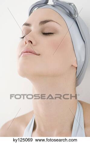 Portrait of a young woman with swimming cap and goggles, eyes closed View Large Photo Image Stock Photo - Portrait of a young woman with swimming cap and goggles, eyes closed. Fotosearch