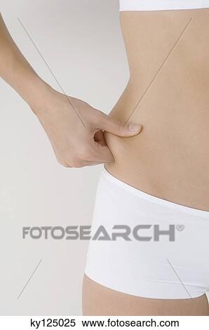 Woman pinching waist, close-up View Large Photo Image Stock Photography - Woman pinching waist, close-up. Fotosearch