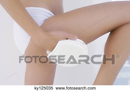 Stock Photography - Woman using massage glove. Fotosearch