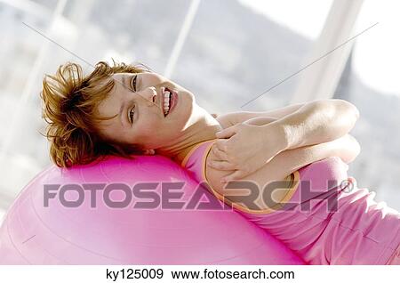 Young smiling woman leaning against big pink balloon View Large Photo Image Stock Photo - Young smiling woman leaning against big pink balloon. Fotosearch