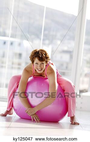 Young smiling woman lying on a big pink balloon View Large Photo Image Stock Photo - Young smiling woman lying on a big pink balloon. Fotosearch