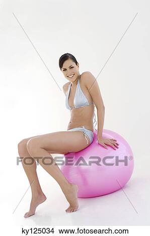 Young smiling woman, sitting on big pink balloon View Large Photo Image Picture - Young smiling woman, sitting on big pink balloon. Fotosearch