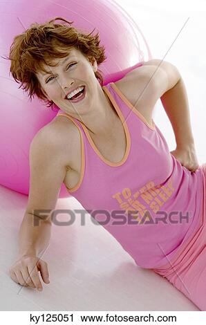 Young smiling woman stting, leaning against big pink balloon View Large Photo Image Stock Image - Young smiling woman stting, leaning against big pink balloon. Fotosearch