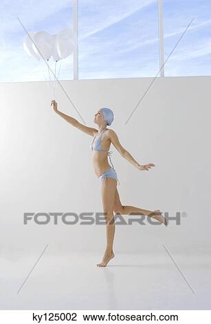 Young woman in bikini and swimming cap, holding white balloons View Large Photo Image Stock Image - Young woman in bikini and swimming cap, holding white balloons. Fotosearch