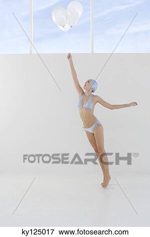 Young woman in bikini and swimming cap, holding white balloons View Large Photo Image Stock Photo - Young woman in bikini and swimming cap, holding white balloons. Fotosearch