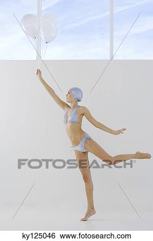 Young woman in bikini and swimming cap, holding white balloons View Large Photo Image Stock Photograph - Young woman in bikini and swimming cap, holding white balloons. Fotosearch