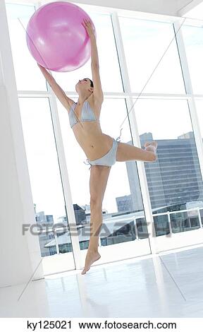 Young woman in bikini, jumping, holding big pink balloon View Large Photo Image Stock Image - Young woman in bikini, jumping, holding big pink balloon. Fotosearch