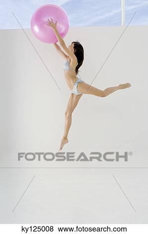 Young woman in bikini, jumping, holding big pink balloon View Large Photo Image Stock Photo - Young woman in bikini, jumping, holding big pink balloon. Fotosearch