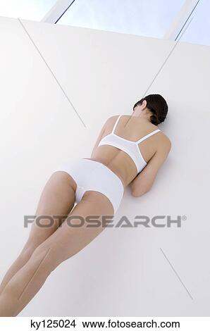Young woman in underwear, leaning against wall View Large Photo Image Picture - Young woman in underwear, leaning against wall. Fotosearch