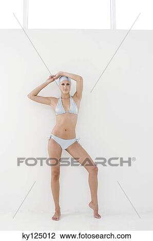 Young woman standing with bikini and swimming cap, arms raised View Large Photo Image Stock Image - Young woman standing with bikini and swimming cap, arms raised. Fotosearch