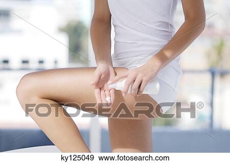 Stock Photo - Young woman using moisturizer. Fotosearch